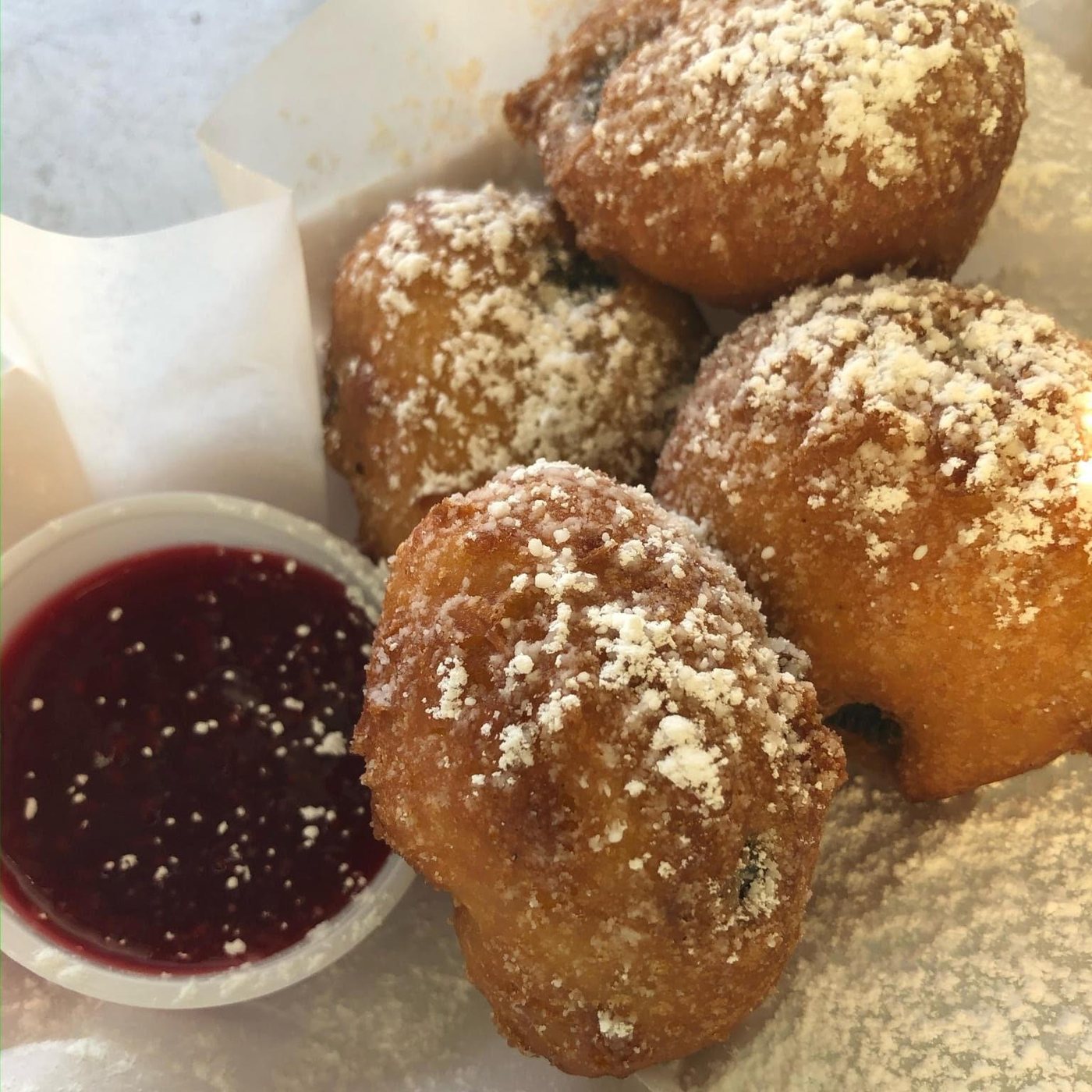 Fried-dough dessert bites with a berry dipping sauce
